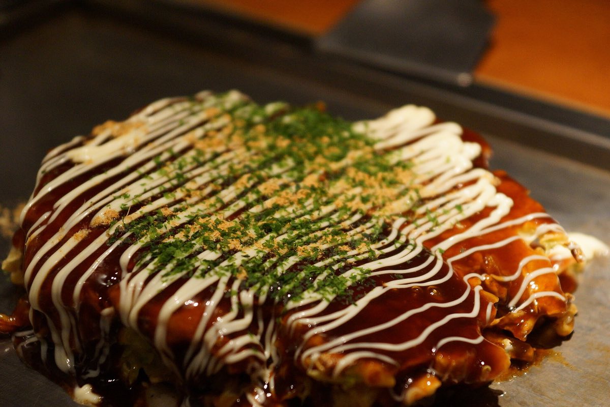Okonomiyaki on a teppan griddle — Commons has no photograph of Hiroshima-style tsukemen